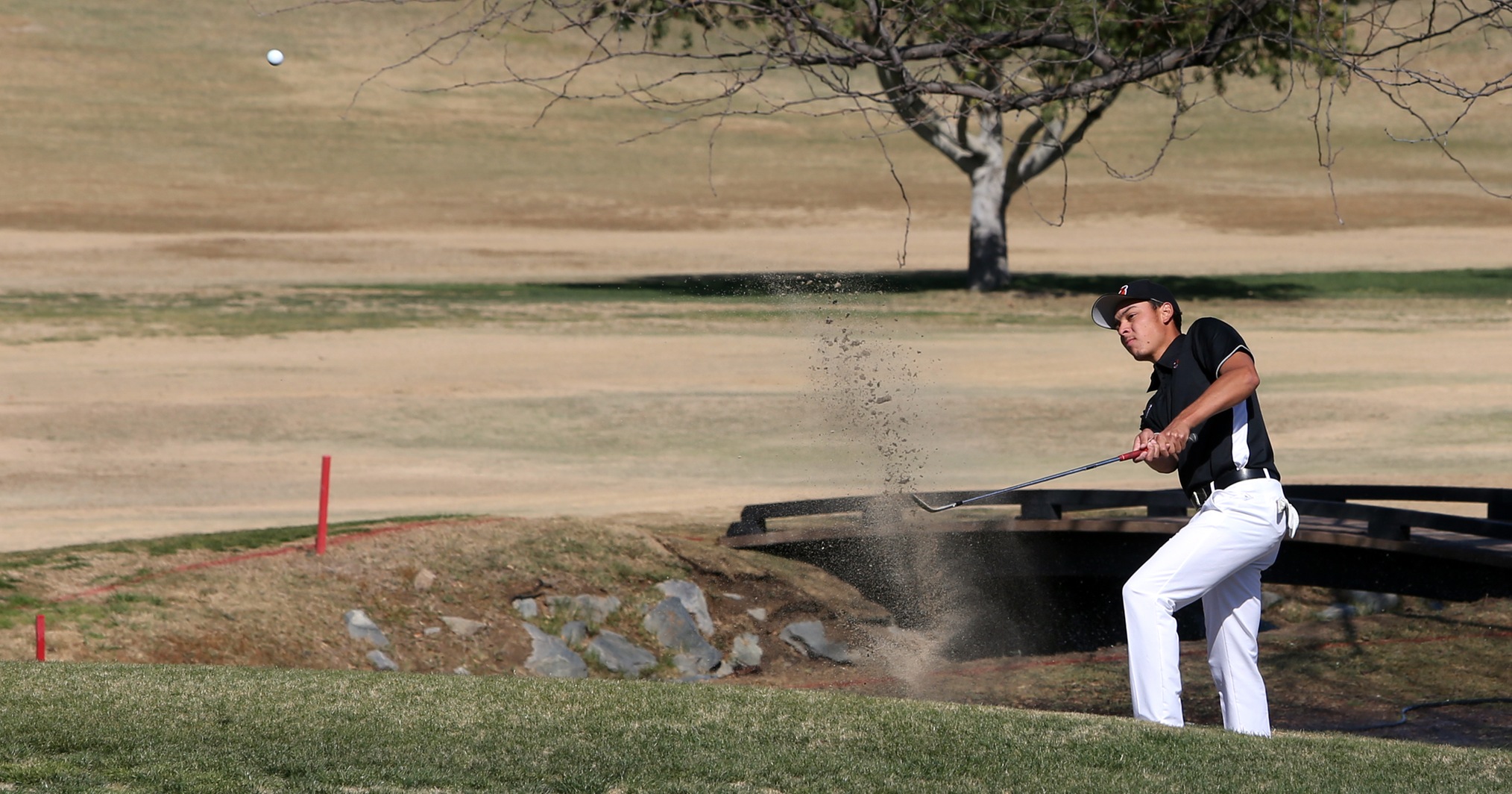 Michael Herrera works his way out of the sand at the Victoria Club during his round at the Riverside Invitational. He finished with a 73. (Photo by Bobby R. Hester)